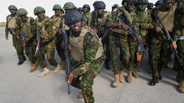 Kenyan police officers, part of a gang suppression force, sing and dance on the tarmac after landing at Toussaint Louverture International in Port-au-Prince, Haiti, Monday, Dec. 8, 2025.