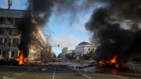 Museums housed inside Ukraine's parliamentary building, pictured here between two burning cars, were damaged by a Russian military strike in central Kyiv on October 10, 2022.