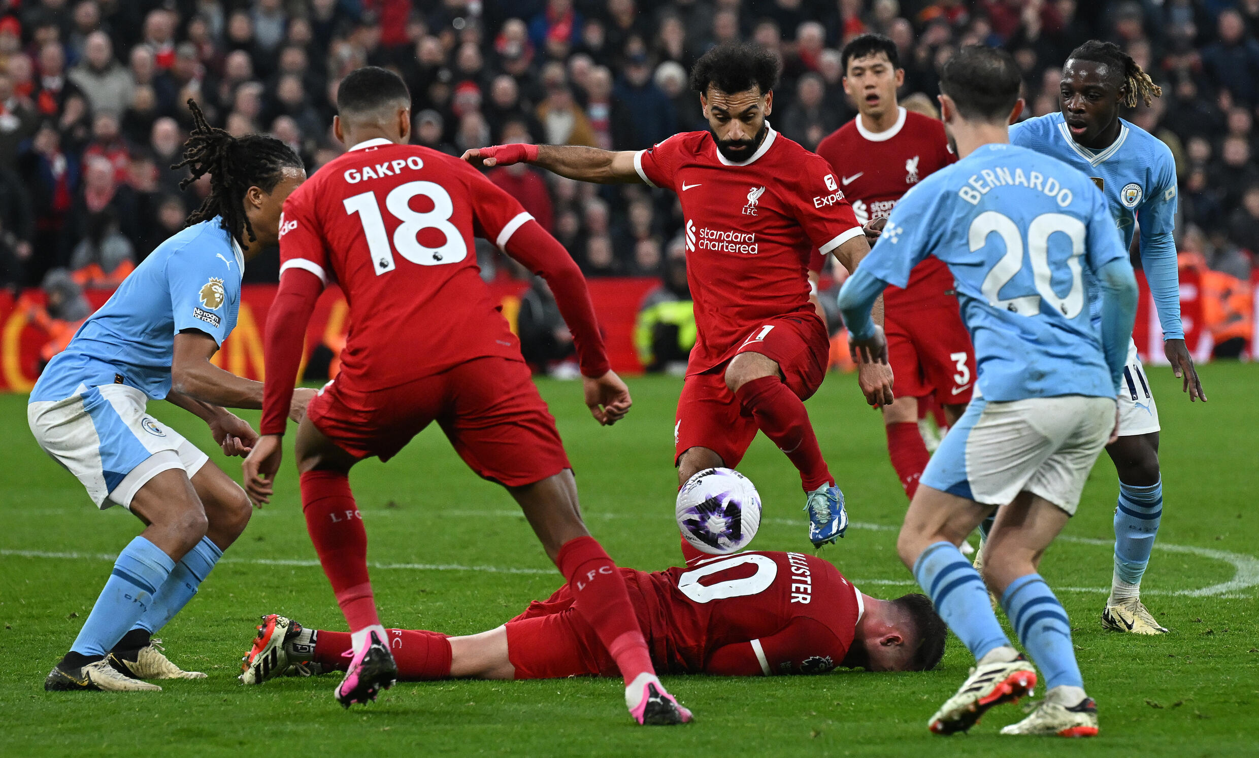 Mo Salah, le milieu de Liverpool, continue à jouer alors que son coéquipier Alexis Mac Allister est au sol, lors du match de Premier League contre Manchester City dimanche à Anfield Road.