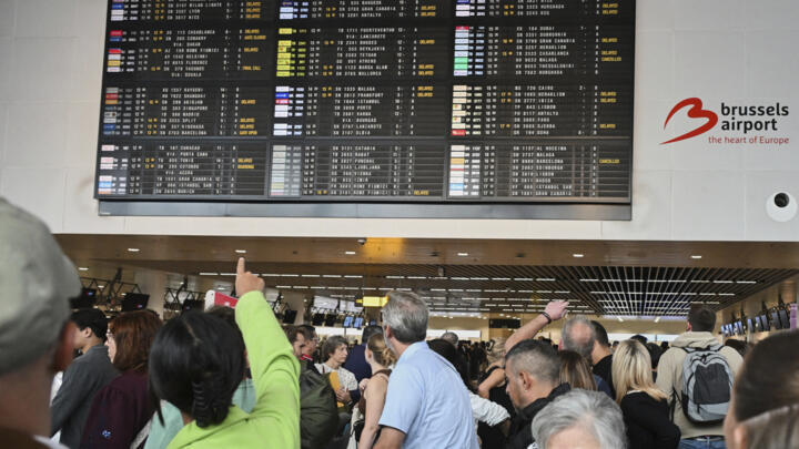 An airport employee points at a departure board after a cyber attack caused delays at Brussels International Airport in Zaventem, Belgium, on September 20, 2025.