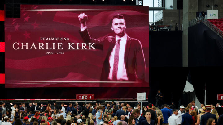 A large screen displays a message in memory of slain conservative commentator Charlie Kirk, as people gather to attend a memorial service, at State Farm Stadium, in Glendale, Arizona.