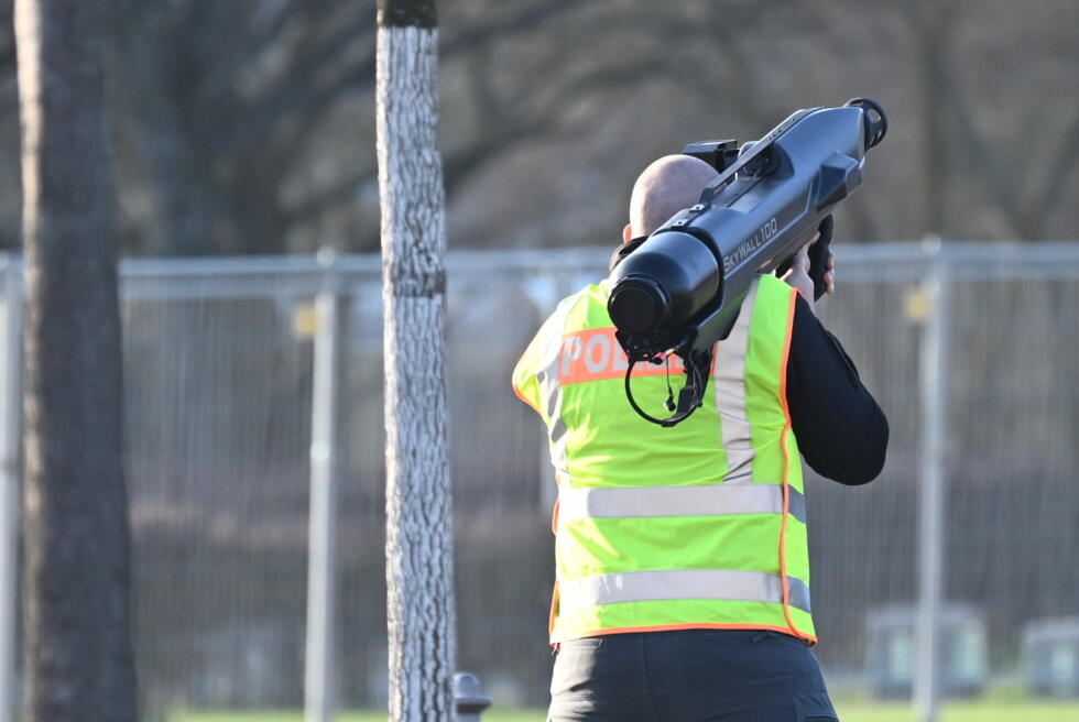 A policeman holds an anti-drone cannon near the chancellery on December 14, 2025 in Berlin