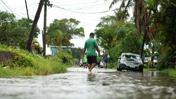 Residents wade through the flooded streets in Fiji's capital city of Suva on December 16, 2020, ahead of super Cyclone Yasa.