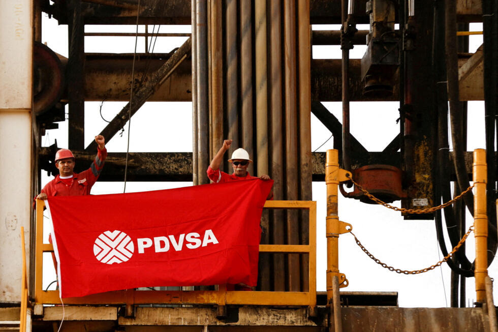 Olieveldarbeiders houden een vlag met het bedrijfslogo van de Venezolaanse staatsoliemaatschappij PDVSA vast op een boorplatform bij een door hen geëxploiteerde oliebron in de Orinoco-gordel.