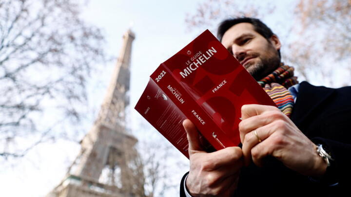 Gwendal Poullennec, International Director of Michelin Guides poses holding a copy of the Michelin Guide 2021 before the ceremony to award stars to French restaurants, in Paris, France, on January 18, 2021.