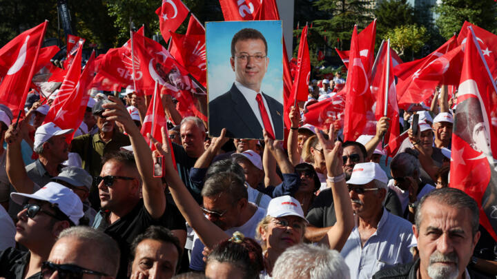 A supporter of the main opposition Republican People's Party (CHP) holds a portrait of jailed Istanbul Mayor Ekrem Imamoglu during a rally in Ankara, Turkey, September 14, 2025.