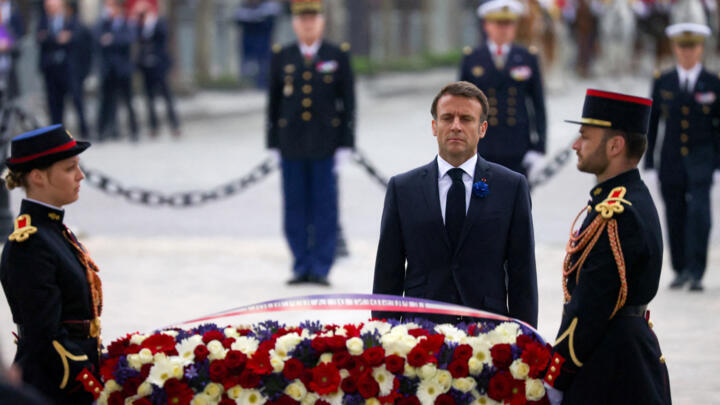 French President Emmanuel Macron lays a wreath of flowers at the Tomb of the Unknown Soldier under the Arc de Triomphe.