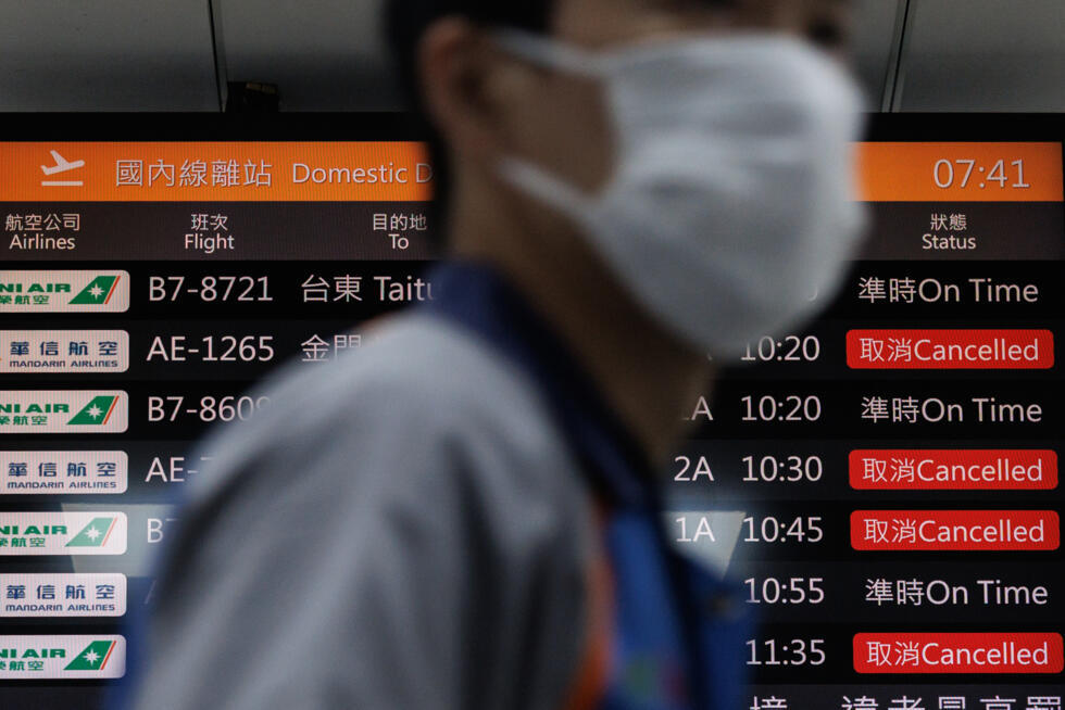 A flight information display board shows cancelled flights at Taipei's Songshan Airport. More than 100,000 passengers were expected to be affected by flight disruptions as a result of China's military