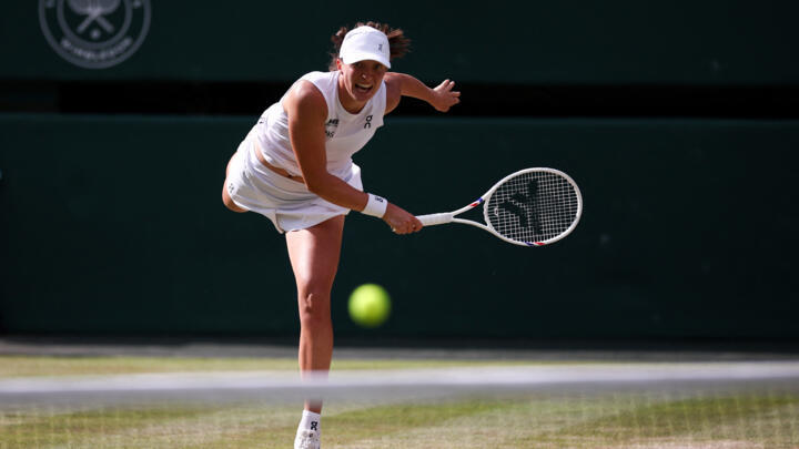 Poland's Iga Swiatek serves to US player Amanda Anisimova during their women's singles final tennis match on the thirteenth day of the 2025 Wimbledon Championships at The All England Lawn Tennis and C