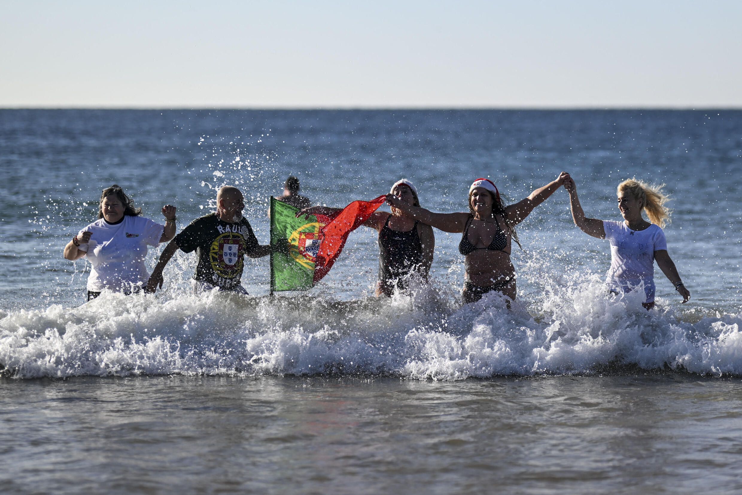 Une baignade enjouée sur la plage de Carcavelos à Oeiras, dans la banlieue de Lisbonne, au Portugal, le 1er janvier 2025.