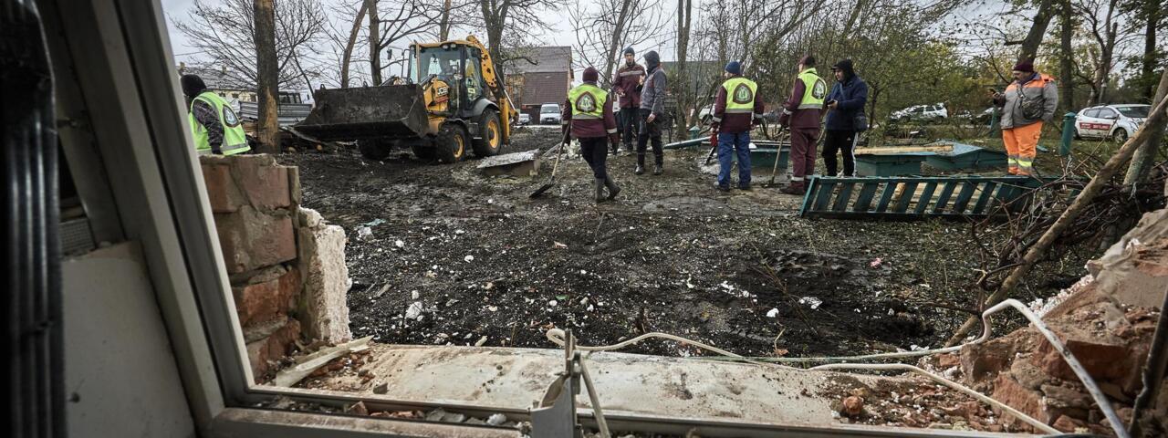 Ukrainian community workers at the site of a Russian airstrike on a building in Kharkiv on October 21, 2025. 
