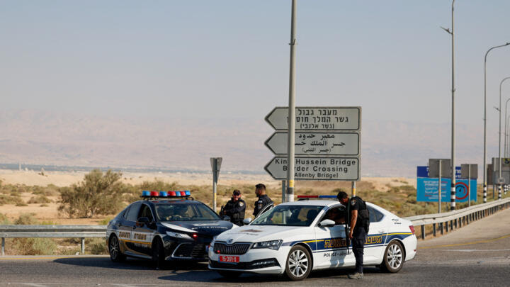 Israeli police officers stand next to their cars at the scene of a fatal shooting at the Allenby Crossing between the Israeli-Occupied West Bank and Jordan, September 18, 2025. 