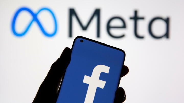 A smartphone with Facebook's logo is seen in front of displayed Facebook's new rebrand logo Meta in this illustration taken October 28, 2021.