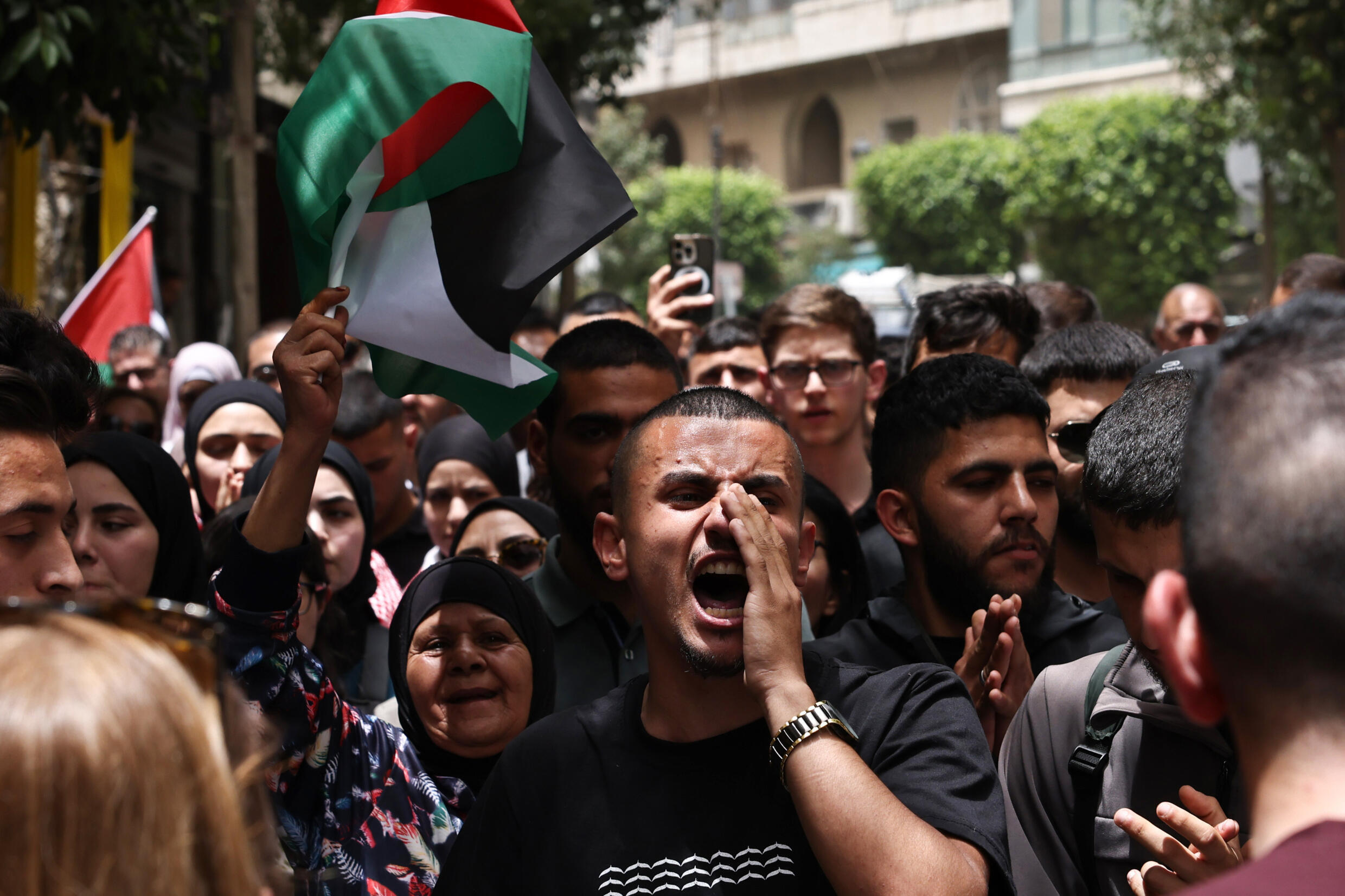 Des personnes scandent des slogans lors d'un rassemblement à Ramallah, en Cisjordanie occupée, le 27 mai 2024, après une frappe nocturne ayant mis le feu à des tentes occupées par des Palestiniens déplacés dans un camp à Rafah, dans la bande de Gaza