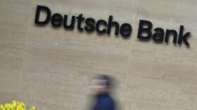 A worker walks past the Deutsche Bank offices in London, Britain on March 16, 2023.