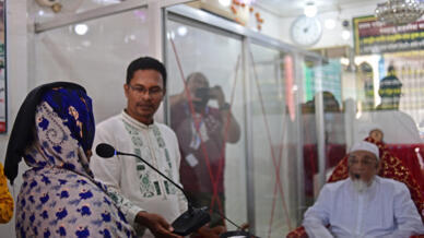 Une femme (g) décrit les symptômes qu'elle ressent au mystique Syed Emdadul Hoque (d), le 14 mai 2022 Maizbhandar, au Bangladesh