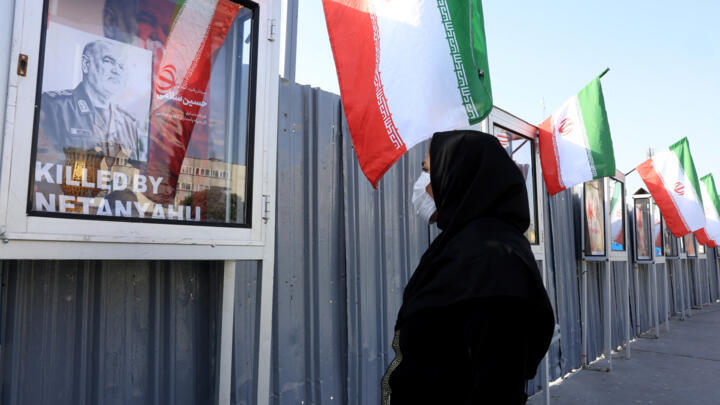 An Iranian woman looks at an image of slain Iranian Islamic Revolutionary Guard Corps (IRGC) commander Hossein Salami at Hafteh-tir Square, in Tehran on June 23, 2025.