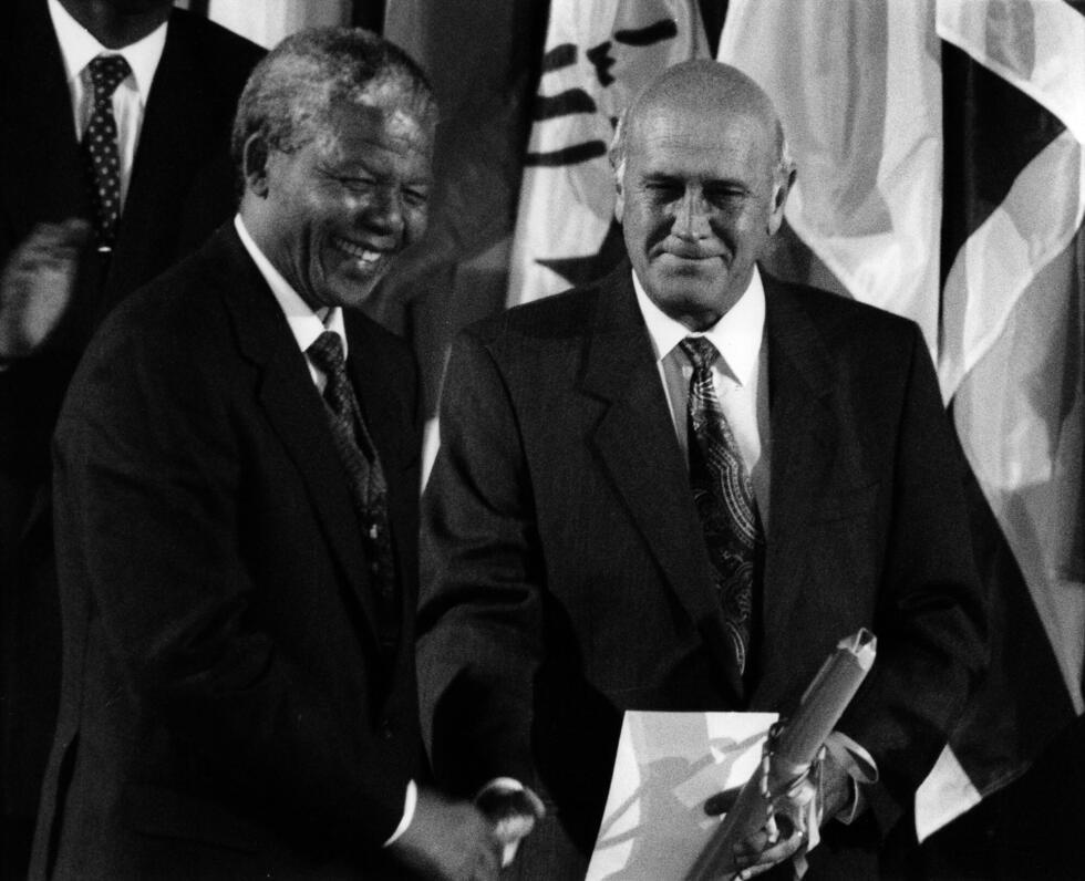 Le président sud-africain Frederik de Klerk, à droite, serre la main du leader de l'ANC, Nelson Mandela, après la remise du prix Unesco pour la recherche de la paix, le 3 février 1992, au siège de l'o