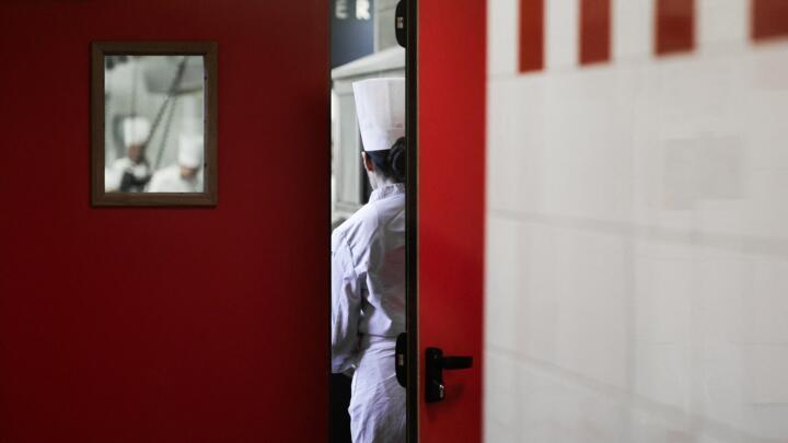 Students in chef uniforms take part in a cooking class in a kitchen in Paris, on March 17, 2025. 