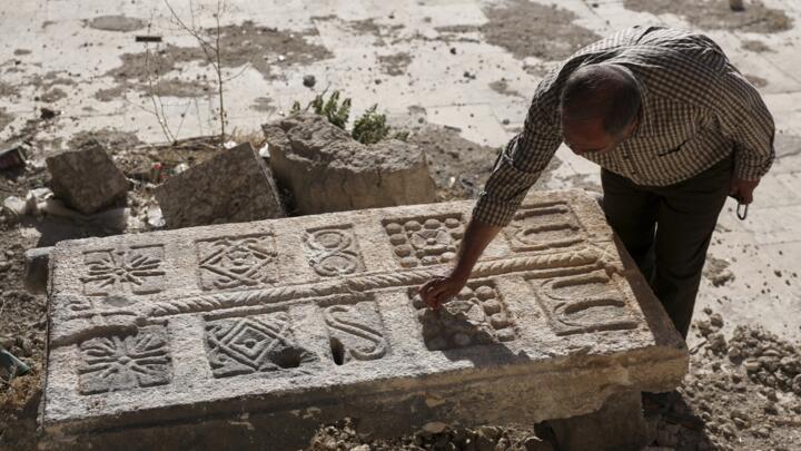 A guard inspects an engraved stone, originally found at a Byzantine underground tomb complex believed to be over 1,500 years old.