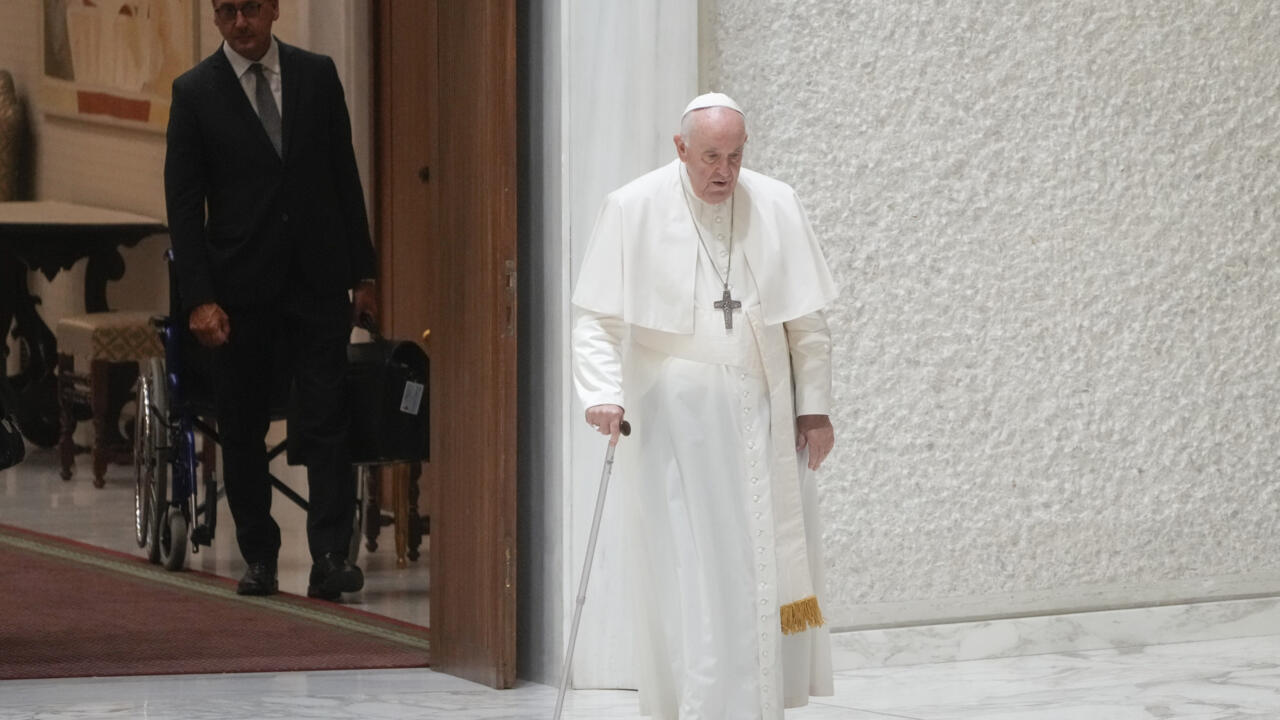 Massimiliano Strappetti, a la izquierda, observa al Papa Francisco caminando en el aula Pablo VI con motivo de la audiencia general semanal en el Vaticano, el miércoles 3 de agosto de 2022. Francisco ha ascendido a la enfermera vaticana a la que atribuyó haberle salvado la vida a ser su «asistente personal de salud». El Vaticano anunció el nombramiento de Massimiliano Strappetti, actualmente coordinador de enfermería del departamento de salud del Vaticano, en una declaración de una línea el jueves.