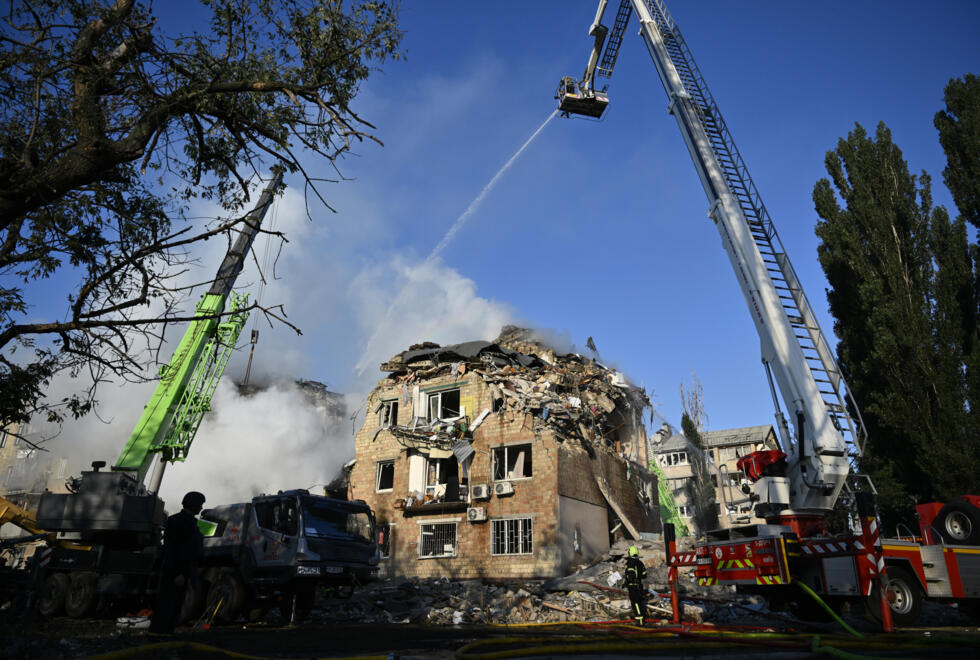 Des sauveteurs ukrainiens sur le site d'un immeuble résidentiel gravement endommagé lors d'une attaque massive de drones et de missiles russes sur Kiev, le 28 août 2025.