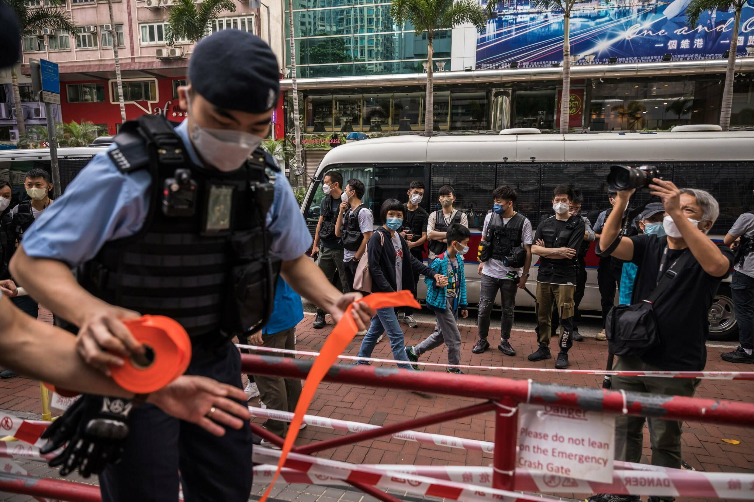 Un officier de police de Hong Kong établit un cordon avant une manifestation de trois personnes contre le processus de sélection du directeur général de la ville