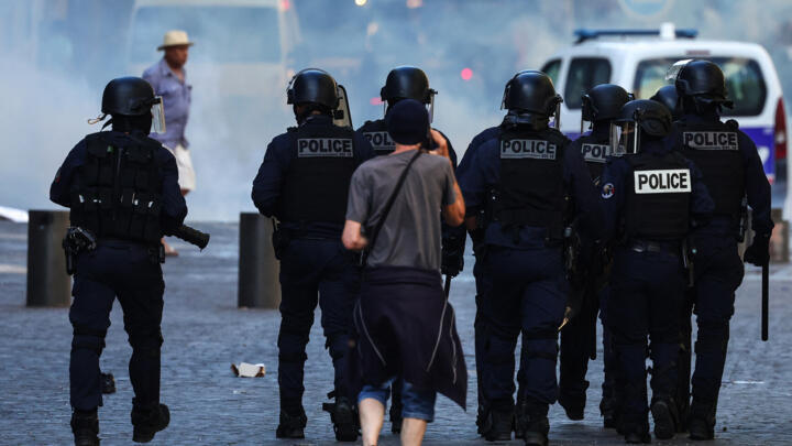 Police officers walk as they try to disperse protesters with tear gas during a demonstration against police in Marseille, southern France, on July 1, 2023.