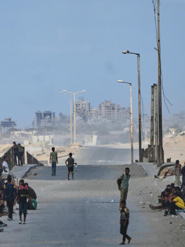 Palestinos desplazados reunidos en la carretera costera cerca de Wadi Gaza, en el centro de la Franja de Gaza, el 9 de octubre de 2025.