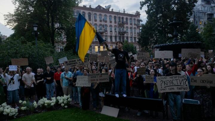 Protesters hold placards during a demonstration calling for the Ukrainian president to veto a law passed by parliament that reduces the powers of Ukraine's National Anti-Corruption Bureau (NABU)