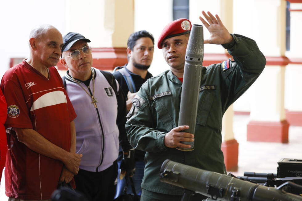 A member of the presidential guard shows weapons during an induction ceremony for volunteers