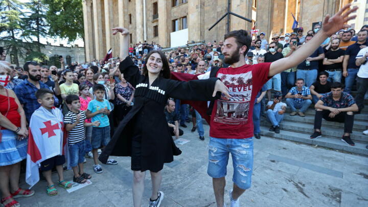 People celebrate in front of the parliament building in Tbilisi, Georgia, July 5, 2021 after LGBT campaigners cancelled a planned pride parade.