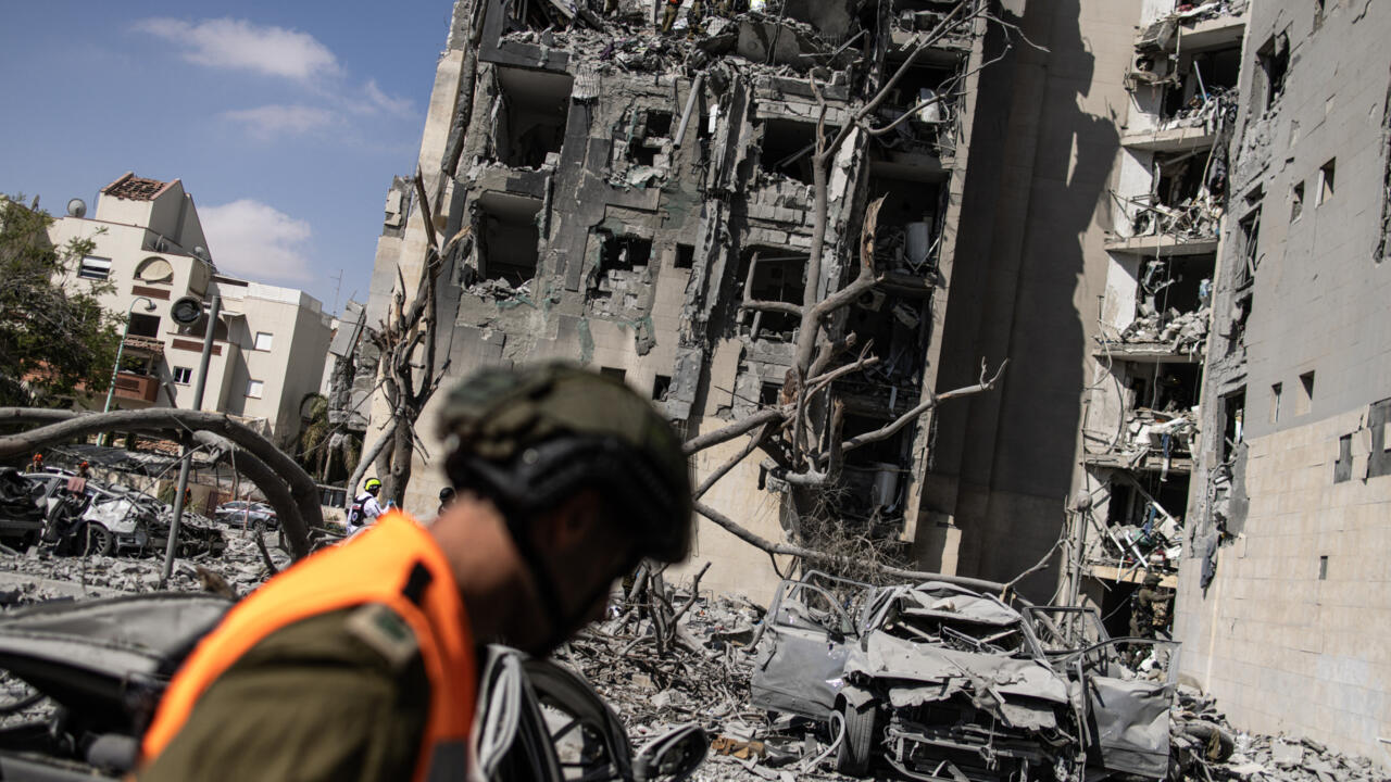 Los servicios de emergencia y agentes de seguridad israelíes buscan víctimas entre los escombros de un edificio impactado por un misil iraní en Beersheba, al sur de Israel, el 24 de junio de 2025.