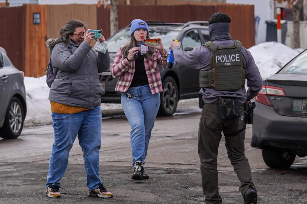 A federal agent points pepper spray at observers in Minneapolis.