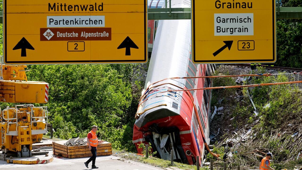 Un trabajador camina cerca de un vagón de tren en el lugar del descarrilamiento de un tren cerca de Burgrain, al norte de Garmisch-Partenkirchen, en el sur de Alemania, el 4 de junio de 2022, un día después del accidente.