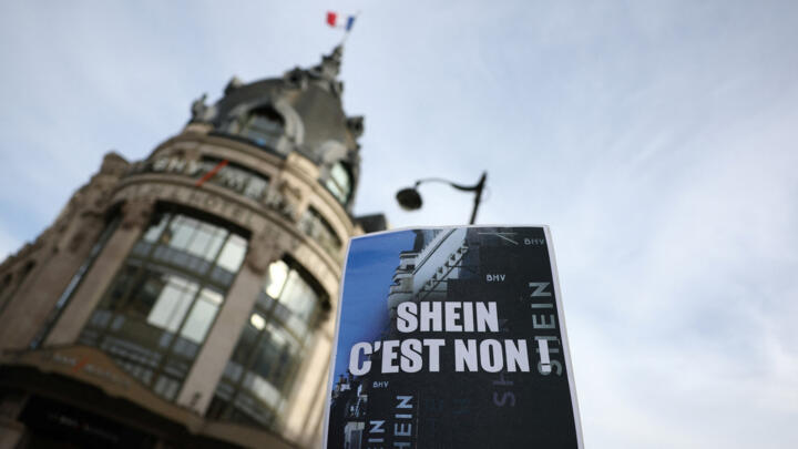 A protester holds a placard which reads "Shein, no way. Stop fast fashion" during a protest against the online fast-fashion retailer's first Paris store, on November 5, 2025.