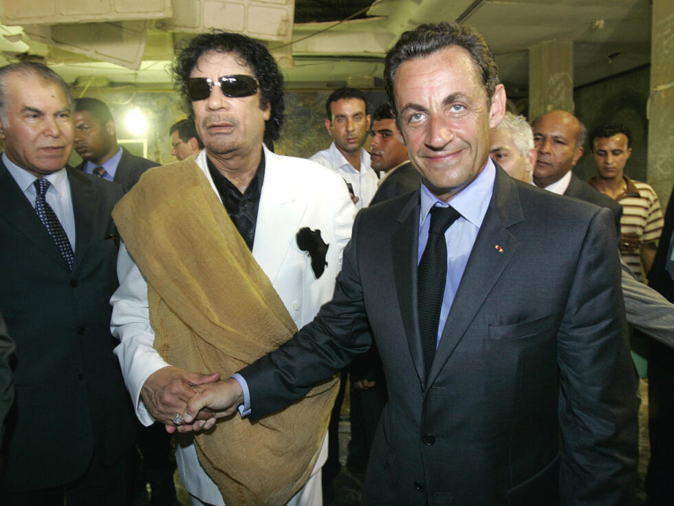 Former Libyan leader Moammar Gaddafi shakes hands with former French President Nicolas Sarkozy in Tripoli on July 25, 2007.