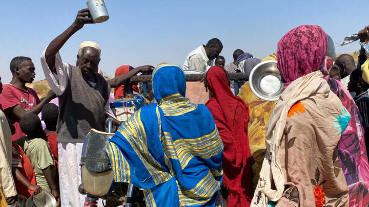 Sudanese who fled el-Fasher city, after Sudan's paramilitary forces killed hundreds of people in the western Darfur region, crowd to receive food at their camp in Tawila, Sudan, Sunday, November 2, 20
