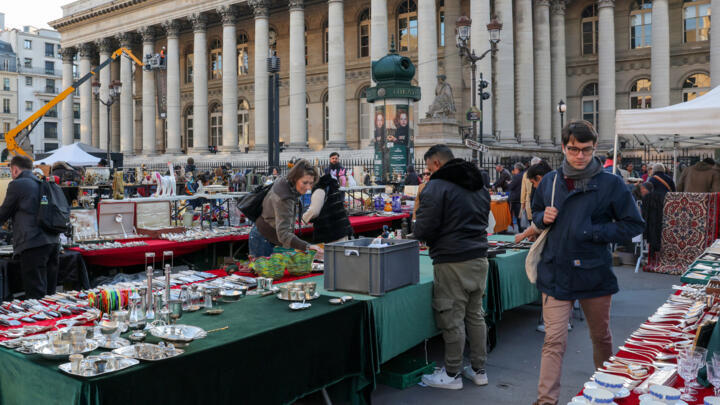 A person walks through a market in front of the former Paris Bourse in Paris, France, April 3, 2025.