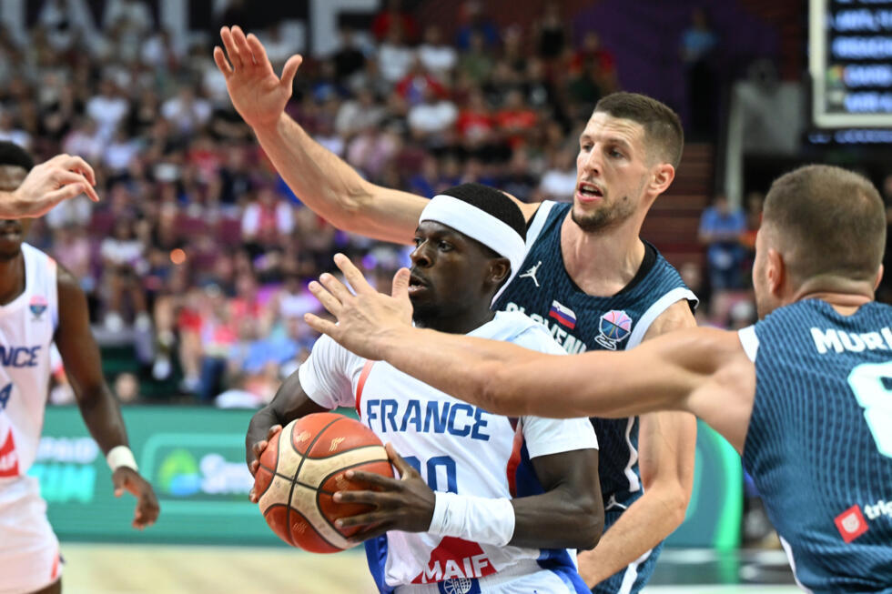 Inarrêtable, le meneur de jeu de l'équipe de France Sylvain Francisco résiste aux  Slovènes Edo Muric et Gregor Hrovat dans le groupe D de l'Euro à Katowice, le 30 août 2025.