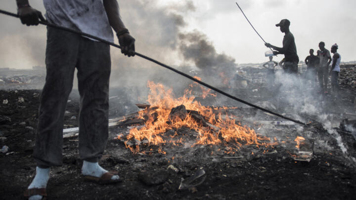 Young men burn electronic waste at Agbogbloshie dumpsite in Accra, Ghana, on November 29, 2017.