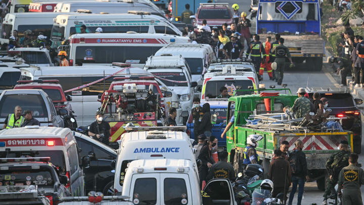 Les services d'urgence sont vus au milieu de la circulation près d'un site de construction où un immeuble s'est effondré à Bangkok le 28 mars 2025, à la suite d'un tremblement de terre.