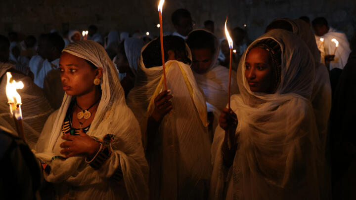 Ethiopian Orthodox Christian pilgrims hold candles during a ceremony of the "Holy Fire" at the Deir Al-Sultan Monastery on the roof of the Holy Sepulchre Church in Jerusalem's Old City on April 15, 2023, on the eve of Orthodox Easter.