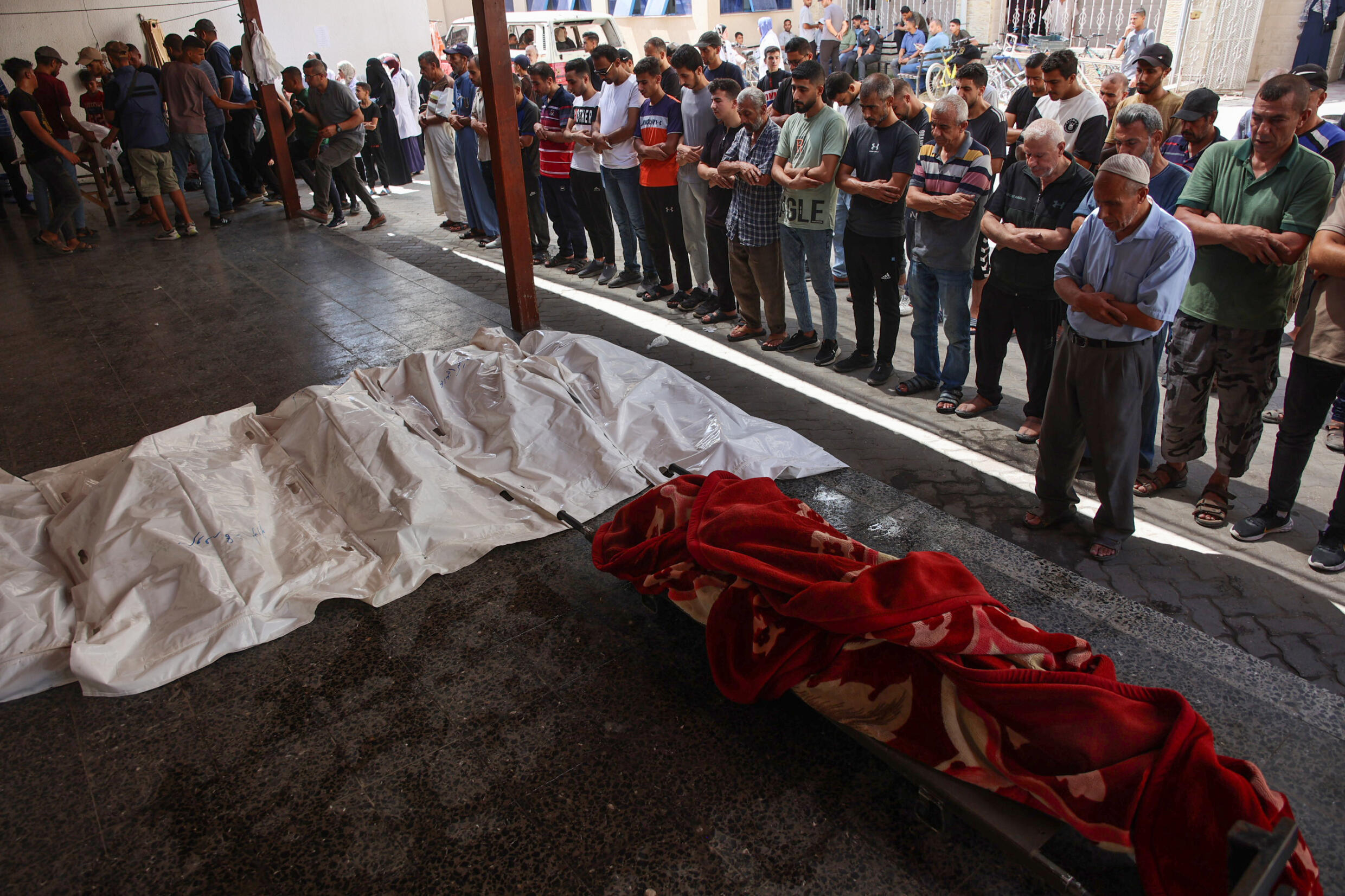 Des Palestiniens prient près des corps de cinq membres d'une même famille tués selon des secouristes par une frappe israélienne à Gaza-ville, le 15 septembre 2024.