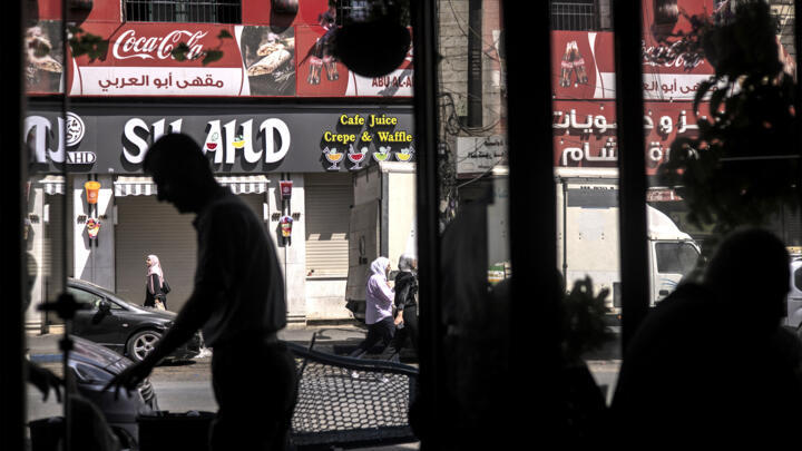People walk along a street in the centre of Ramallah in the occupied West Bank on September 22, 2025.
