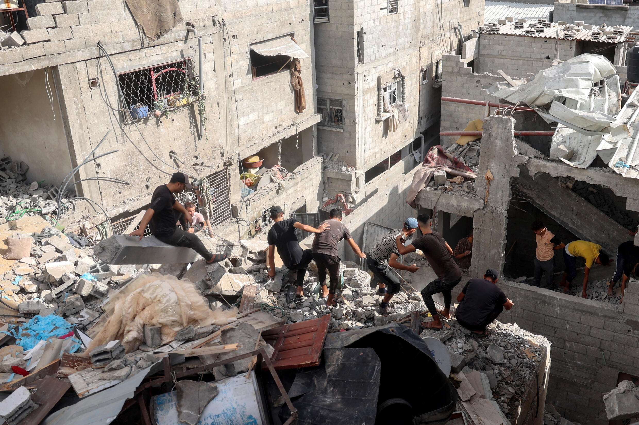 Des Palestiniens inspectent les décombres d'une maison après un bombardement israélien à Nousseirat, dans le centre de la bande de Gaza, le 16 septembre 2024.