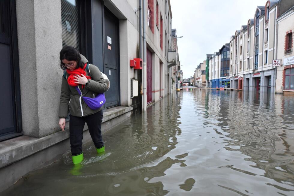 Une habitante quitte sa maison et marche dans une rue inondée à Redon,  le 30 janvier 2025.