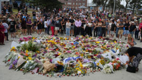 People gather around a tribute for shooting victims outside the Bondi Pavilion at Sydney's Bondi Beach, December 15, 2025, a day after a shooting