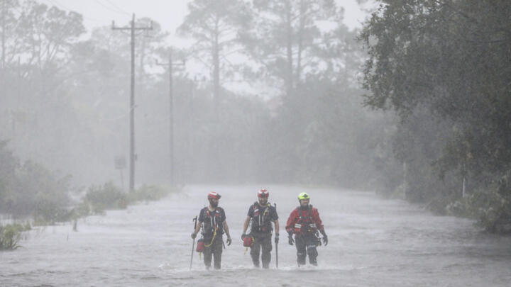 Rescue workers wade through a tidal surge in Steinhatchee, Florida on August 30, 2023.