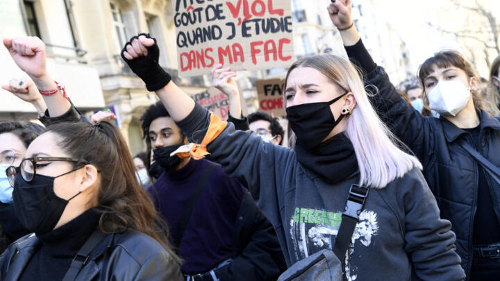 A protester raises her fist with a placard behind her that reads: "There is a taste of rape when I'm studying at uni", during a demonstration for women's rights on March 6, 2021.